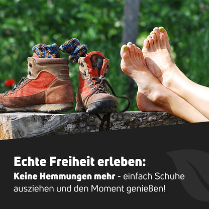 Bequeme Füße und Wanderschuhe auf einer Holzplattform, die Freiheit und Schuh-Hygiene symbolisieren.